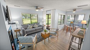 A spacious living area with a grey sofa, striped armchair, wooden coffee table, and a dining table with chairs. - W Hyde Pk 7C in Kingston 1st floor, Pool, Beach (Myrtle Beach)