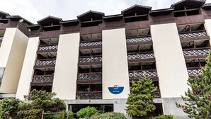 Un hotel de varios pisos con un diseño arquitectónico moderno, que presenta un logotipo destacado en la fachada.