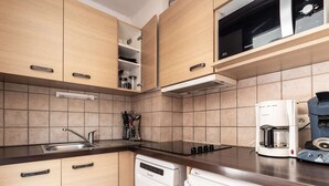 Una cocina moderna con armarios de madera, lavavajillas, cafetera y microondas.