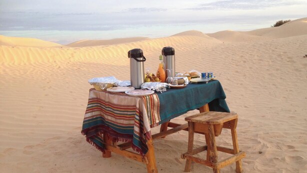 Una mesa instalada en el desierto con vistas a dunas de arena.