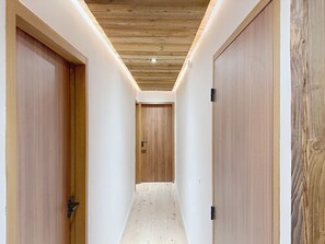 Un couloir étroit avec des portes en bois et un plafond en bois.