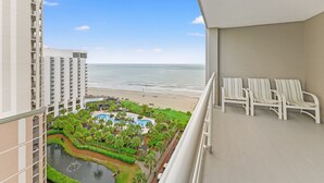 Un hotel de gran altura con vista a la playa y una zona de piscina.