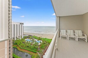 Ein Hochhaus-Hotel mit Blick auf Strand und Poolbereich.