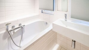 A modern bathroom with a bathtub, a shower, and a sink. - 1-bedroom Apartment in National Residence (Antwerp)