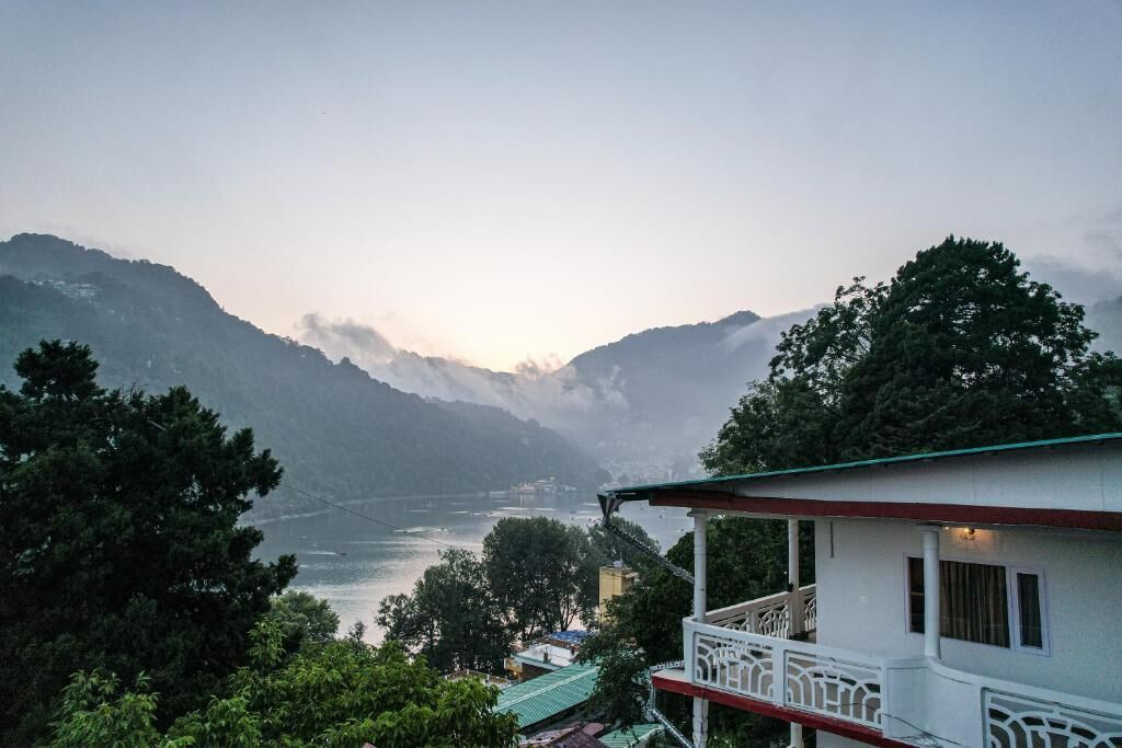 A building with a balcony overlooking a valley and a river.