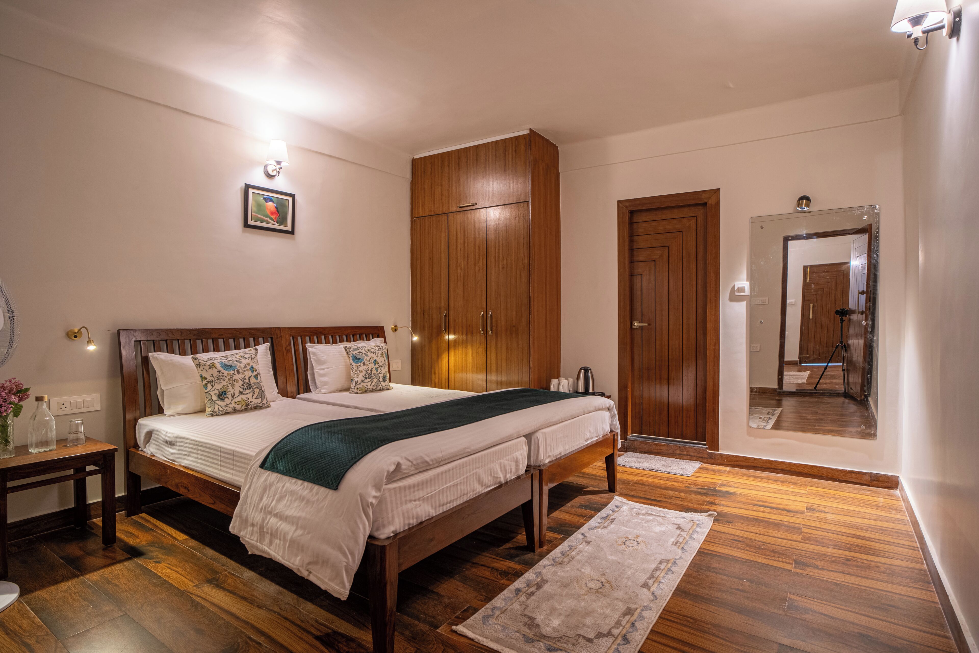 Um quarto com cama de madeira, guarda-roupa, espelho e mesa de cabeceira.