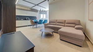 Un salon moderne avec un canapé, une table basse et un coin repas avec des chaises.