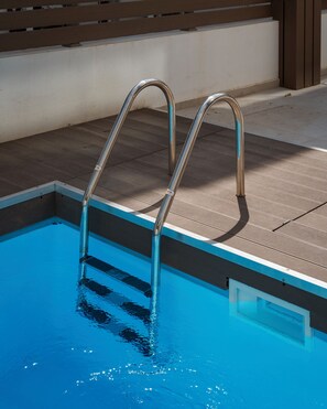 A swimming pool with metal ladders and a tiled deck area. - Alimos Escape 1 (Alimos)