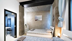 Un dormitorio con cama, mesita de noche y un cuadro en la pared.