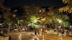 Un espace public extérieur doté de coins salon, d’arbres et où l’on peut voir des gens.