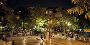 An outdoor public space with seating areas, trees, and people. - Modern 1-Bedroom Condo in Athens (Athina)