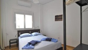 Une chambre à coucher avec un lit, une table de chevet, une fenêtre et un tableau au mur.