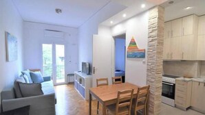 Un espace de vie compact comprenant un coin repas, une kitchenette et un canapé.
