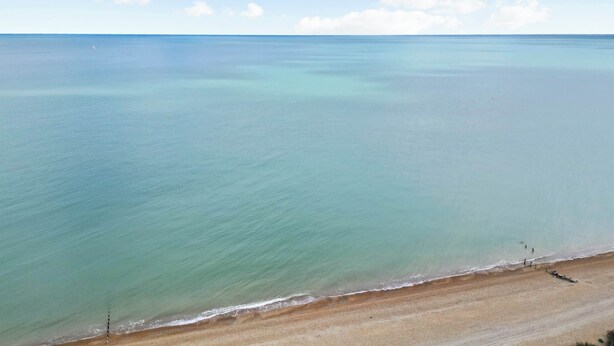 Ein Strand mit klarem Wasser und sandigem Ufer.