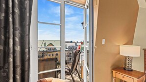 A room with a large sliding glass door leading to a balcony with a chair and a lamp.