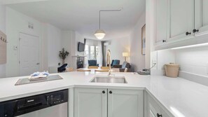 Eine moderne Küche mit Geschirrspüler, Spüle und Essbereich mit Stühlen.
