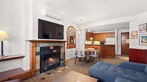 Ein Wohnzimmer mit Kamin, Fernseher und einer Couch.