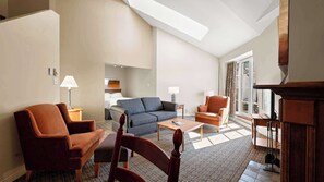 Ein modernes Wohnzimmer mit einer Couch, Sesseln, einem Couchtisch und einem Kamin.