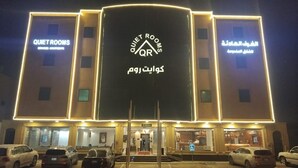 A hotel with 'Quiet Rooms' signage, a central entrance, and multiple cars parked in front. - Quiet Rooms 13 (Riyadh)
