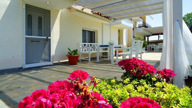 A covered outdoor area with a white bench, a table, and potted plants. - Apartment '1' with Mountain View, Wi-Fi and Air Conditioning (Fanari)