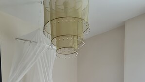 Ein Schlafzimmer mit Bett, Nachttisch, Lampe und Baldachin.