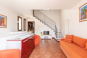 A modern living room with a kitchen, a staircase, and a sofa. - Gem of Mondello by Wonderful Italy (Palermo)