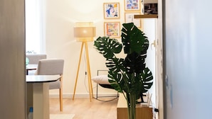 A hallway with a potted plant, a lamp, and framed artwork on the wall. - Tremendous 3-bedroom apartment with AC & Fast Wi-Fi in New Cairo City (New Cairo City)