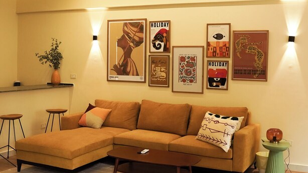 A living room with a sectional sofa, a coffee table, and wall-mounted lighting. - Tremendous 3-bedroom apartment with AC & Fast Wi-Fi in New Cairo City (New Cairo City)