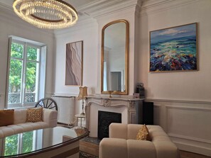 A room with a fireplace, a large mirror, a painting, and a sofa. - Elegant 130m² A/C Apt – Square Gambetta (Carcassonne)