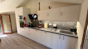 A modern kitchen with white cabinets, a built-in oven, a coffee maker, and a sink. - Charming countryside residence, swimming pool (Allemans)