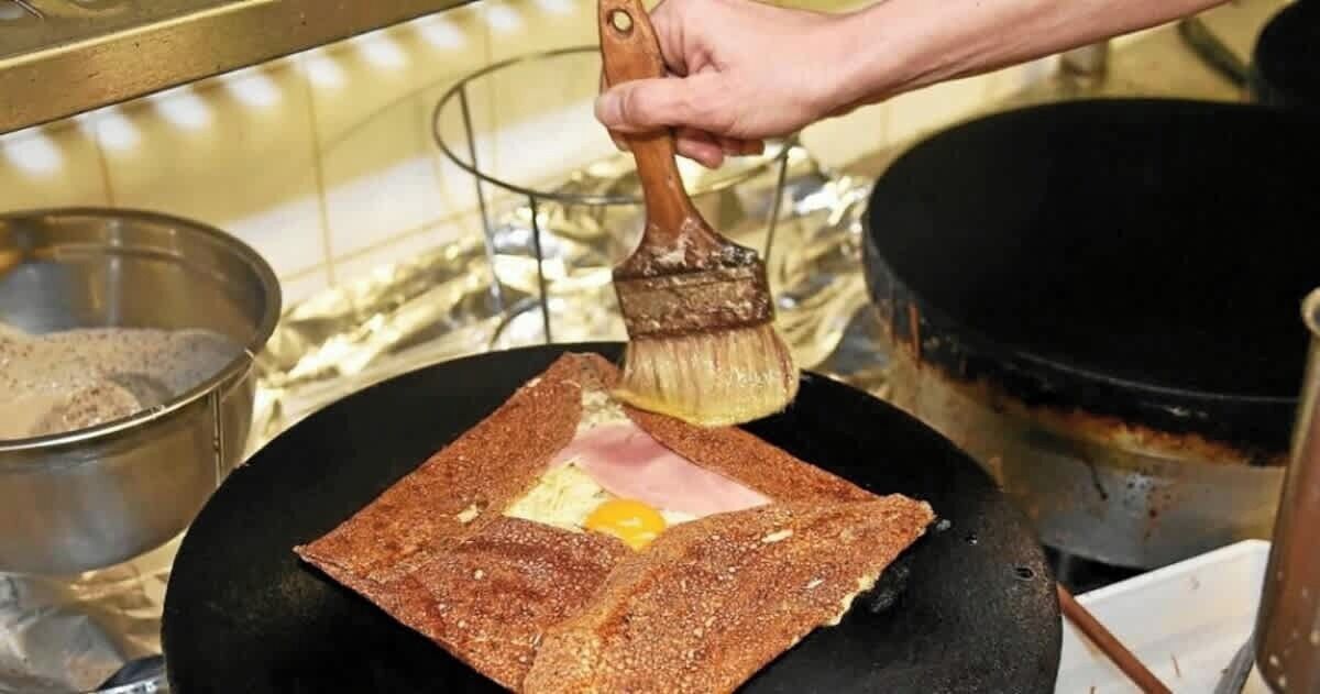 Una persona cocinando un sándwich en una sartén.