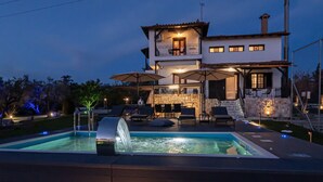 A two-story house with a swimming pool, outdoor seating, and a stone wall. - Stone Vista by RentalsPro - Nea Poidaia Halkidiki (Nea Poteidaia)