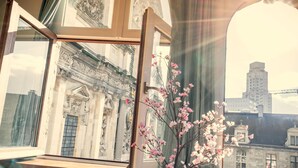An open window with a view of a building's facade and a vase with flowers. - Loft-style Duplex at Hendrik Square (Antwerp)