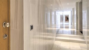 A corridor with marble walls and floors, leading to a staircase. - Lodge Apartment in Central Antwerp (Antwerp)