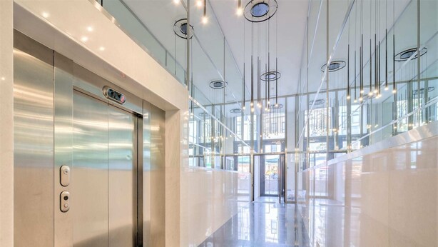 A modern elevator with a digital display, a polished floor, and a glass wall reflecting the interior. - Lodge Apartment in Central Antwerp (Antwerp)