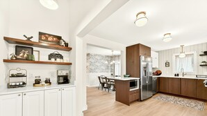 A modern kitchen with white cabinetry, wooden accents, and a central island. - Sagewood Retreat! Updated spacious home on quiet st., 3 blocks from Mayo Clinic (Rochester)