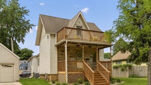 A two-story house with a front porch, a garage, and a well-maintained lawn. - Sagewood Retreat! Updated spacious home on quiet st., 3 blocks from Mayo Clinic (Rochester)