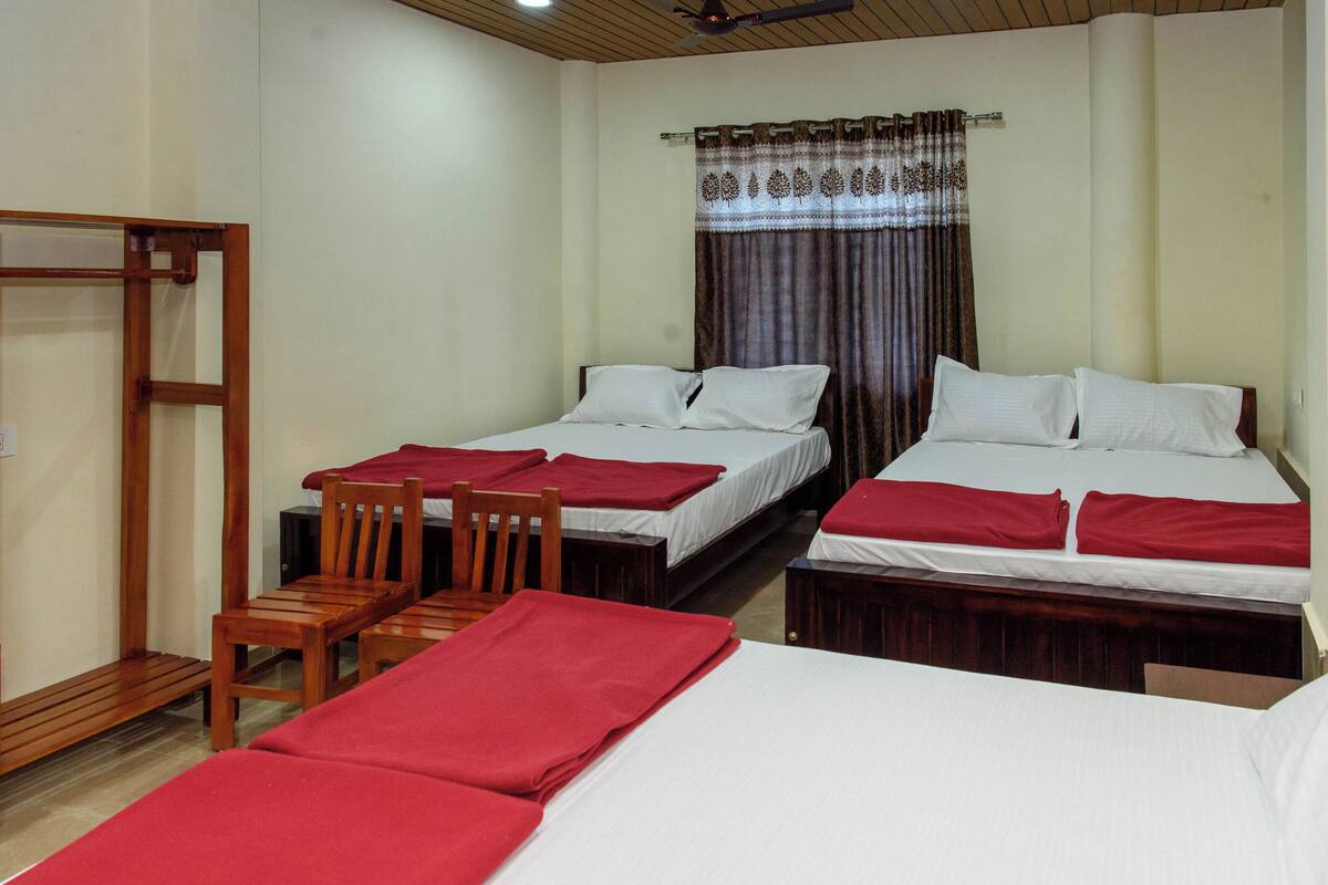 A room with two single beds, a wooden chair, and a small table.