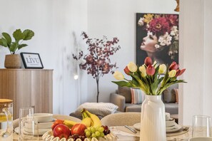 A dining table with fruit, a vase of tulips, and a framed picture on the wall. - LIVU Admiral: 130sqm apartment | an old town dream + roof terrace (Wismar)