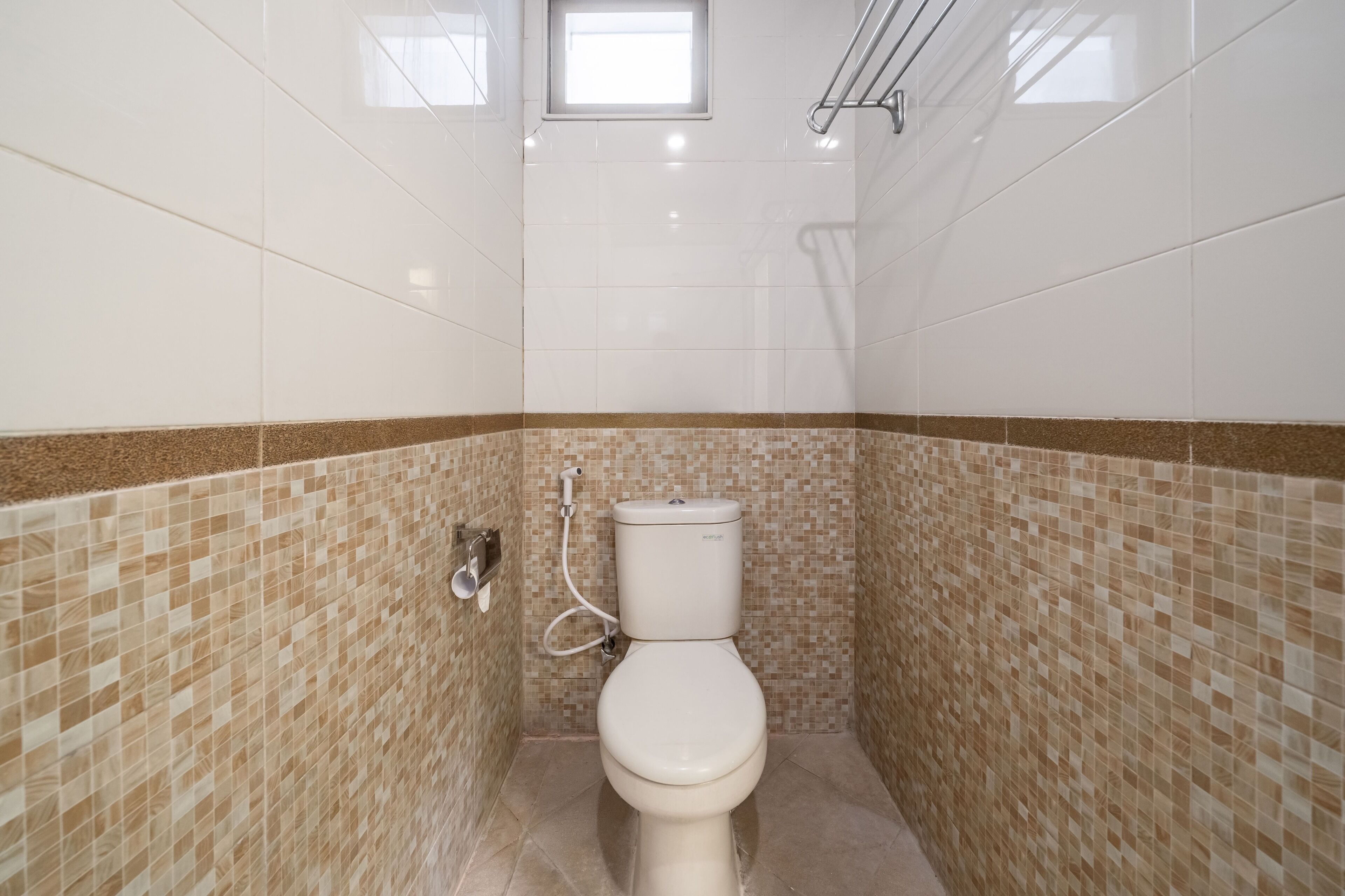 A bathroom with a toilet, a shower, and a window.