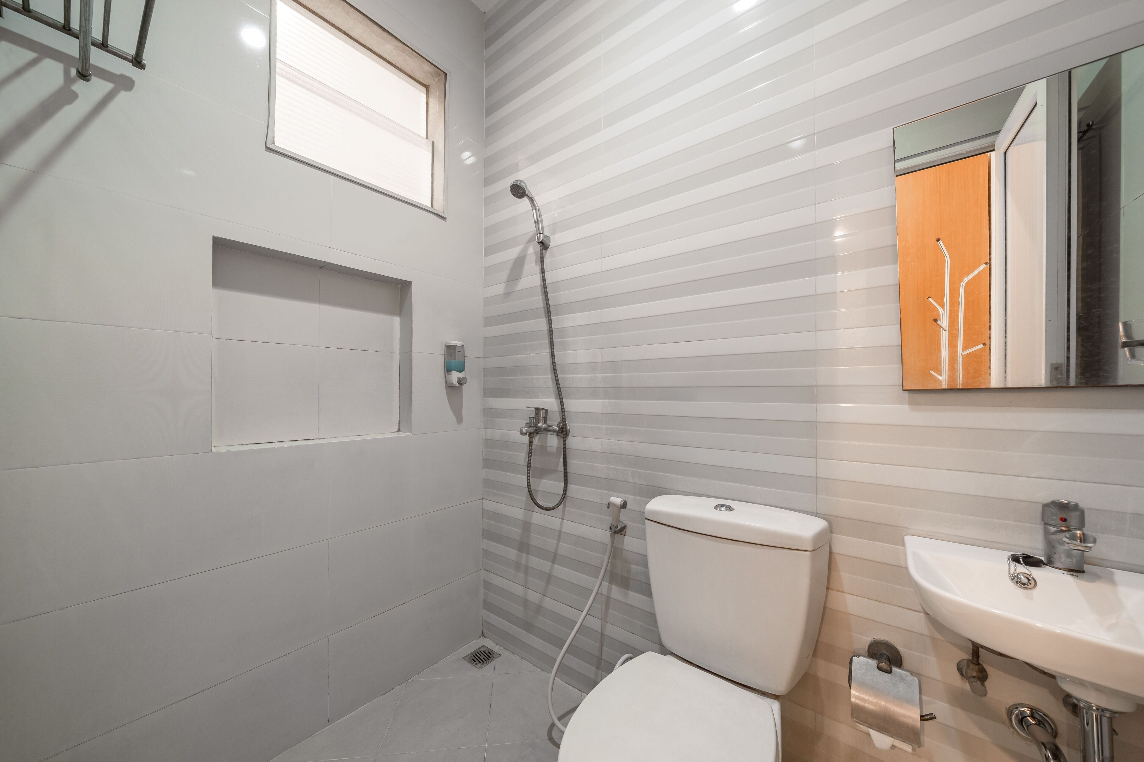 A modern bathroom with a shower, toilet, and sink.