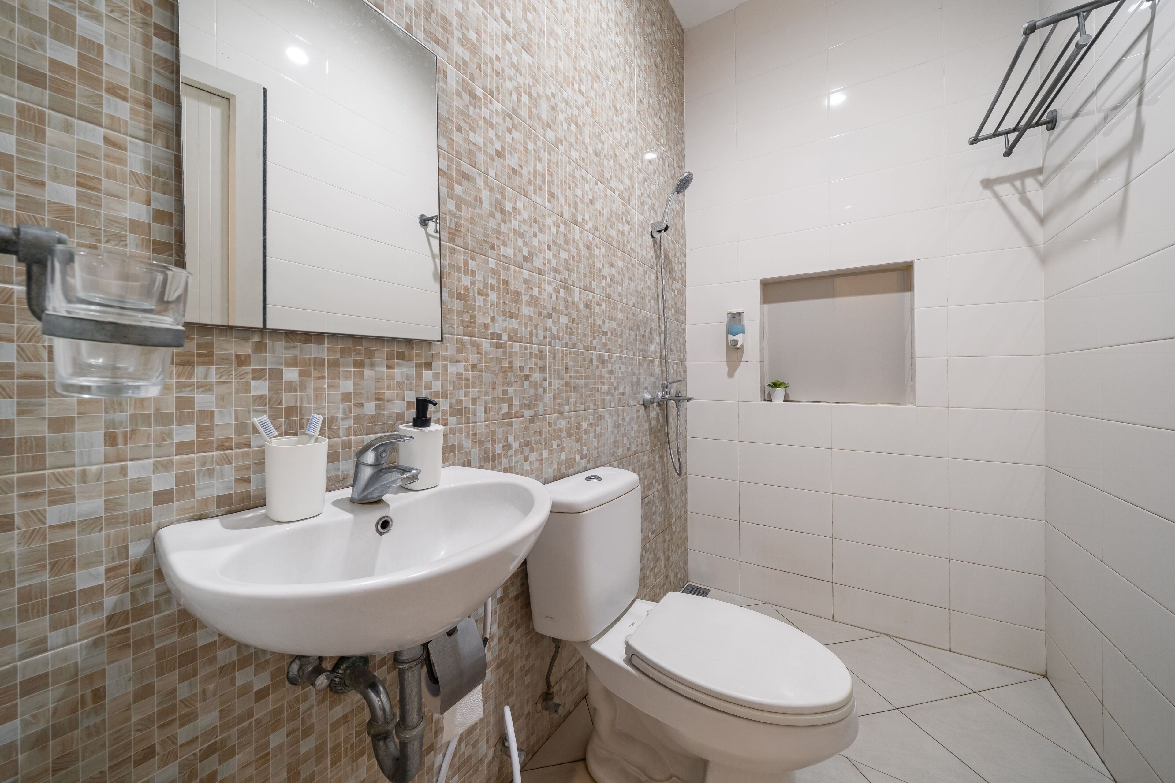 A bathroom with a sink, toilet, and shower.