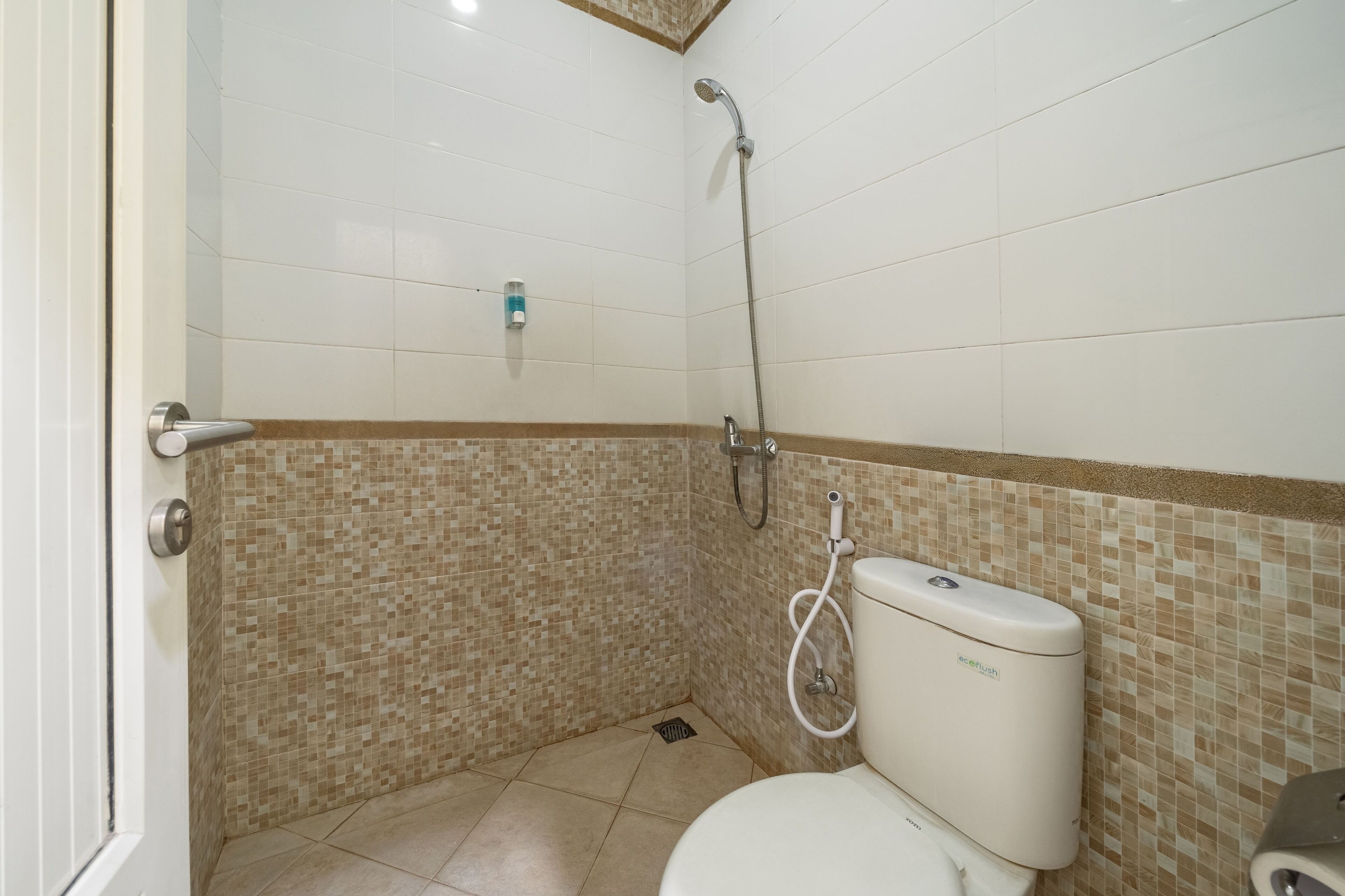 A bathroom with a shower, toilet, and a hand dryer.