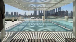 Una piscina en la azotea con vistas a la ciudad, zona cubierta y sistema de drenaje.