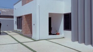 A modern building with a flat roof, a brick chimney, and a white facade.