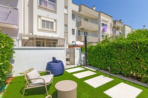 A residential building with balconies, a small garden with artificial grass, and a seating area with a chair and a round table. - Cozy apartment of 60 sqm, ideal for 4 people, located on the ground floor of a building (with some steps at the entrance).The property is located in a residential area, well served and strategically positioned: just 200 mt from Otranto station, convenien (Otranto)