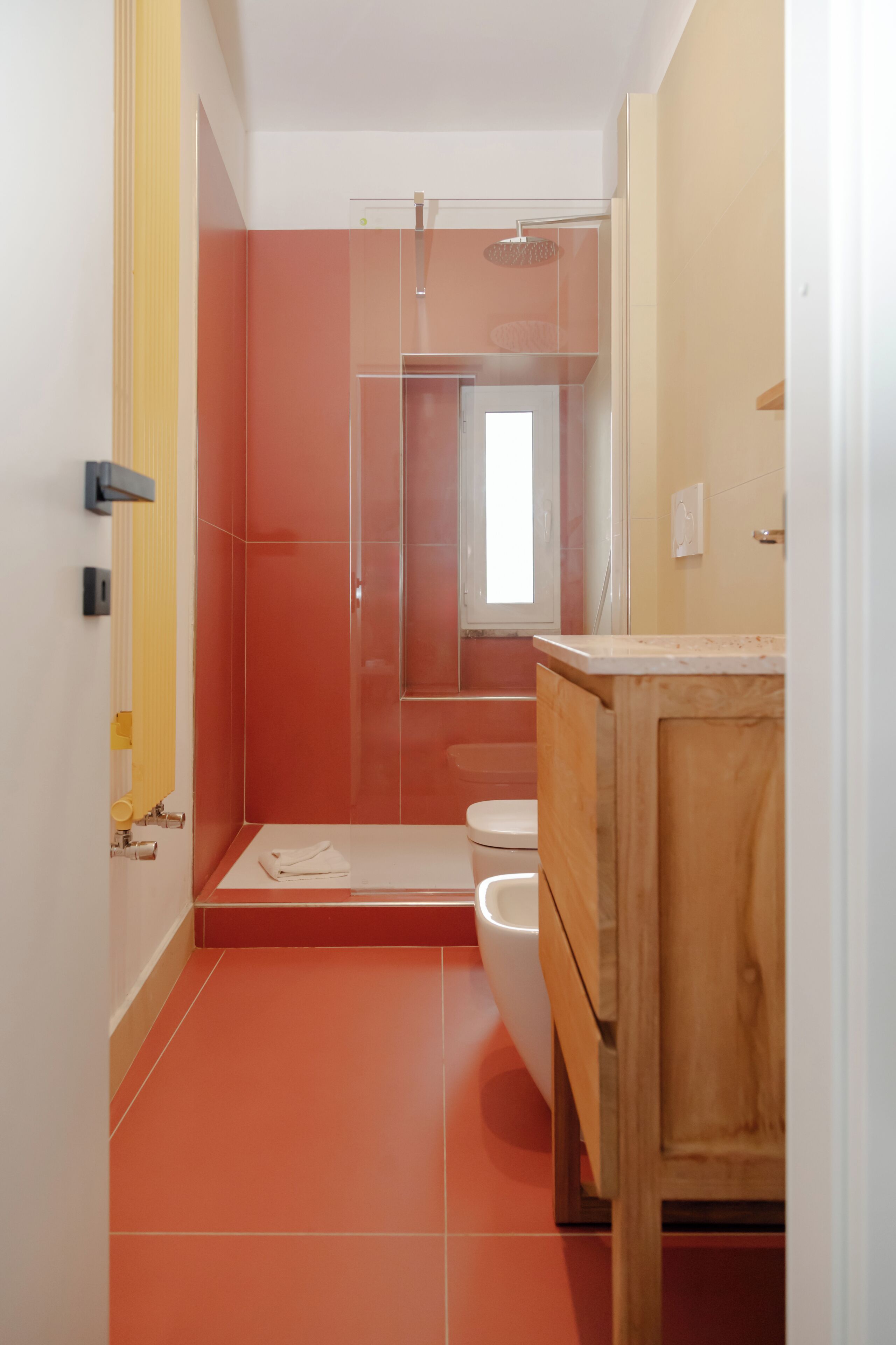 A bathroom with a shower, toilet, and wooden vanity.