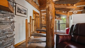 Eine Holztreppe mit Steinstufen, ein Ledersofa und eine Uhr an der Wand.