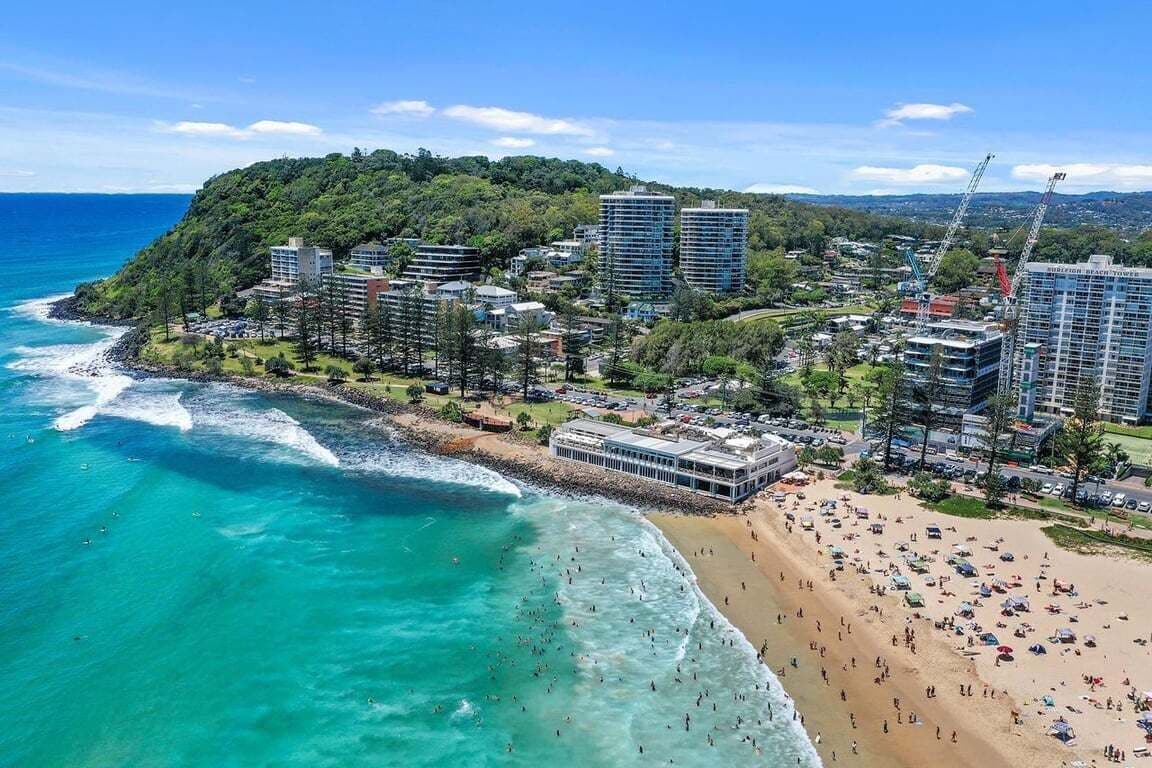 A coastal resort with beachfront properties, a sandy beach, and a view of the ocean.