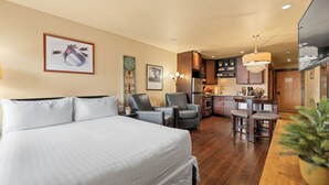 Une chambre d’hôtel avec un grand lit, un bureau et une kitchenette.